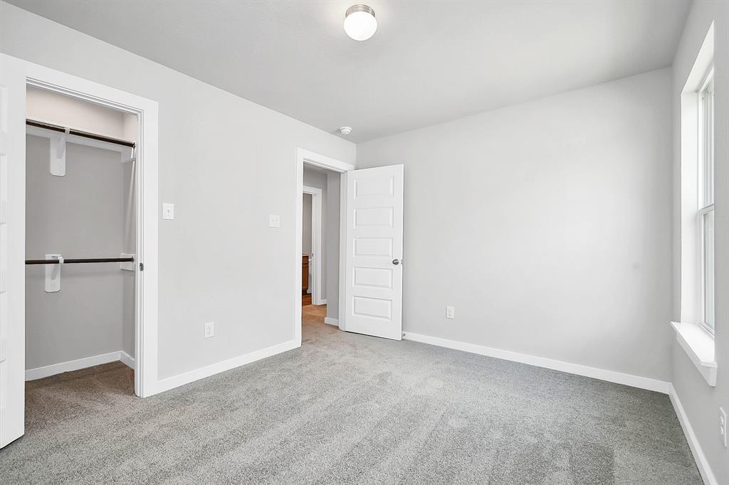 Secondary bedroom features plush carpeting, large windows that let in plenty of natural light, bright paint, and spacious closets.