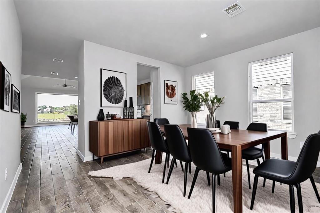 Craft enduring memories with loved ones around the table! This roomy dining area boasts stylish flooring, personalized paint, and is conveniently situated next to the family room and kitchen, fostering an open and inclusive ambiance.