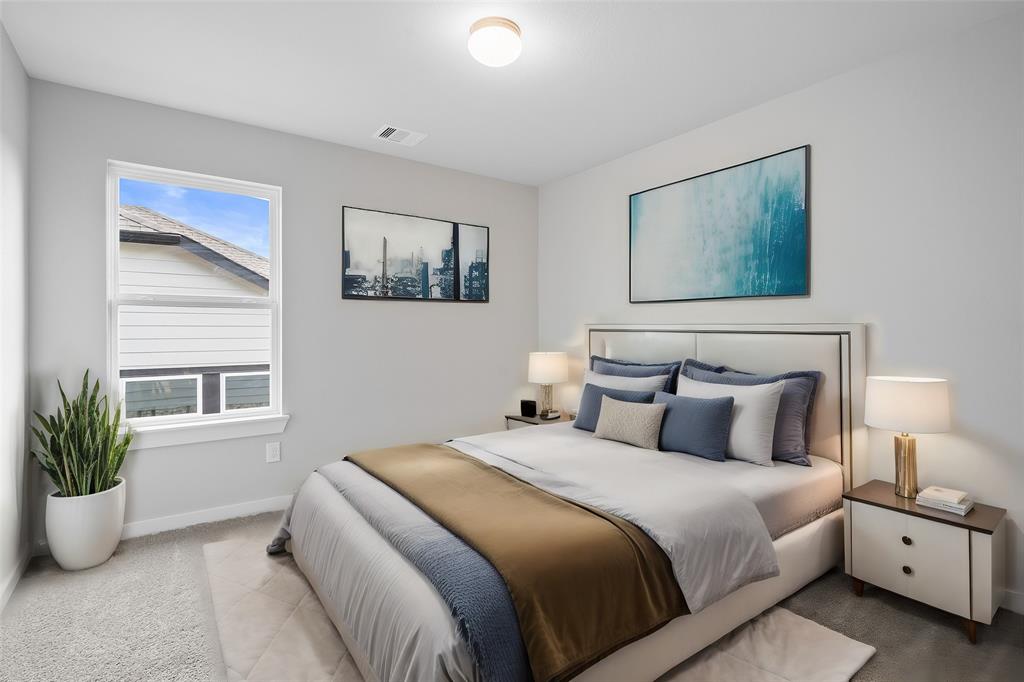 Secondary bedroom features plush carpet, custom paint, ceiling fan with lighting and a large window with privacy blinds.