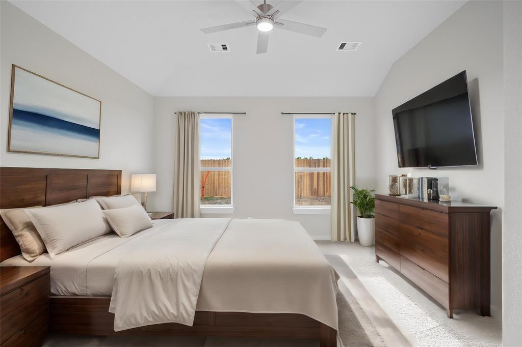 Come and unwind after a long day in this magnificent primary suite! This spacious room features plush carpet, warm paint, high ceilings, ceiling fan and large windows with privacy blinds.