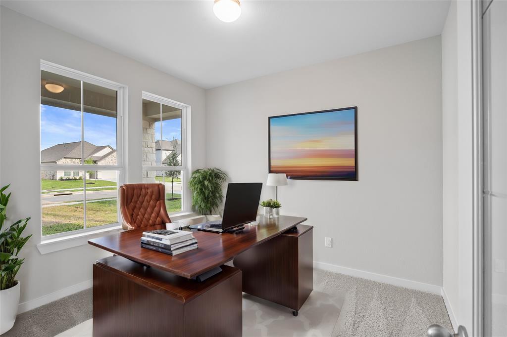 Quietly nestled in front of the home is the handsome home office. Featuring gorgeous flooring, custom paint, ceiling fan and large windows with privacy blinds.