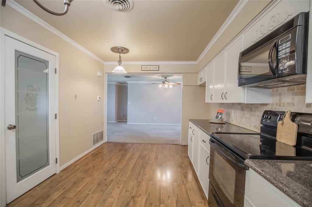 Kitchen flows seamlessly to the family room and LOOK at the darling pantry door. Homeowner had a small table under the pendent light.