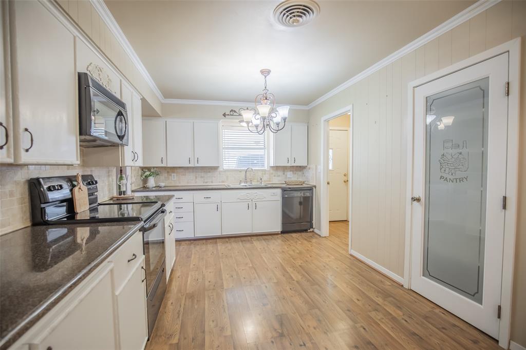 Doorway to the back left leads to the indoor laundry room, 2nd bath and exits to the carport for an easy grocery haul. Homeowner had a moveable butcher block island under the chandelier.