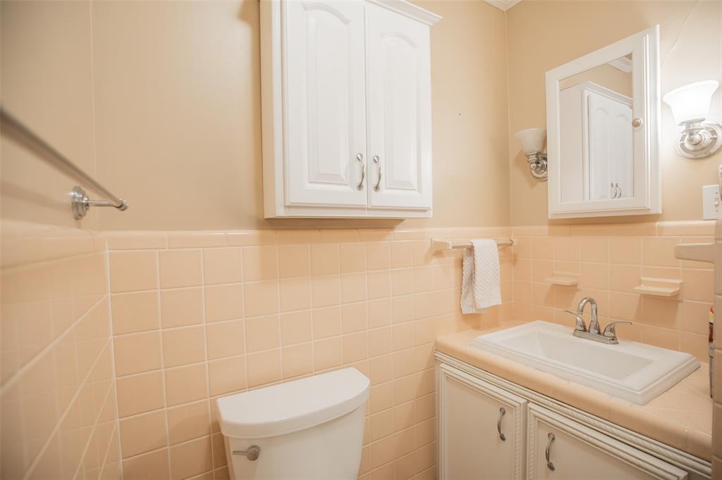 Bathroom 1 - LOOK at this... Chrome fixtures and faucets and double sconce lighting that flanks the mirrored medicine cabinet. The tiled soap dishes are delightful.