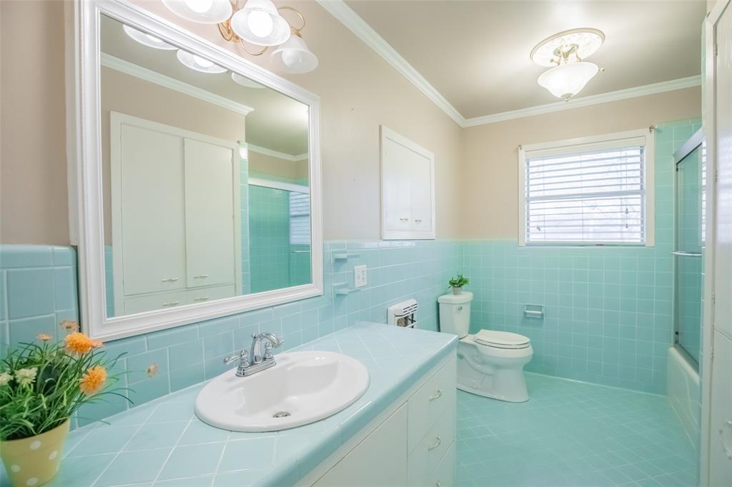 The MOST CHARMING vintage bathroom is in PERFECT condition. Chrome faucet, framed mirror, cabinet pulls, wall cabinet, pretty lighting and soap dish/toothbrush holders.