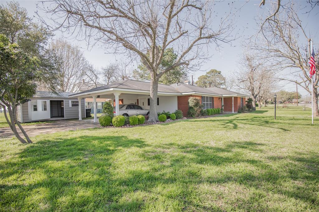 Appreciate how the carport is aesthetically and structurally connected to the home and roofline. The flag pole and light post are unexpected and pleasant features in the front yard.