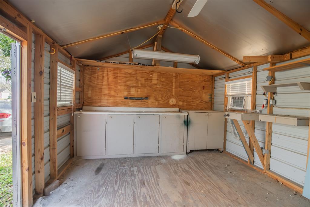 Cabinets, counters, shelves, lighting, wall AC unit, ceiling fan, cool-ply roofing makes for an excellent workshop.