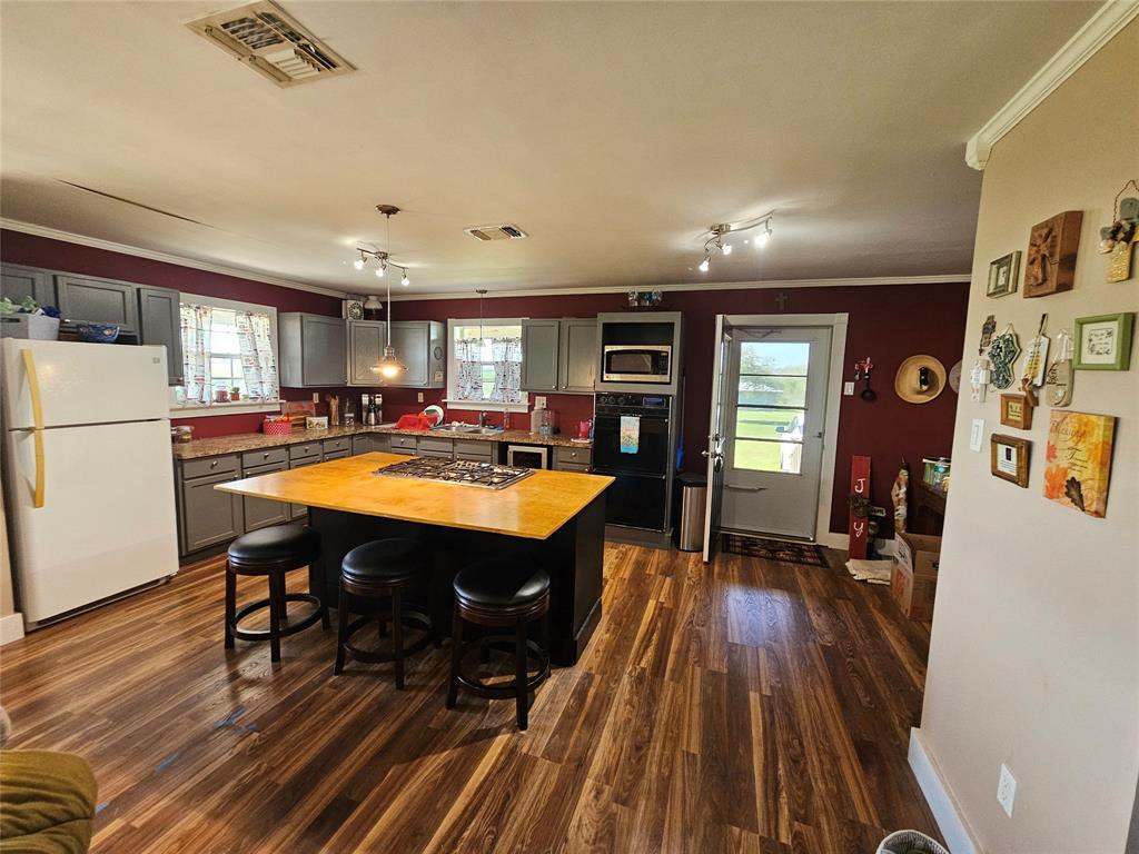 Storm door out to covered side porch. Double electric oven. Microwave. Fridge. Wine chiller. Window over the kitchen sink.