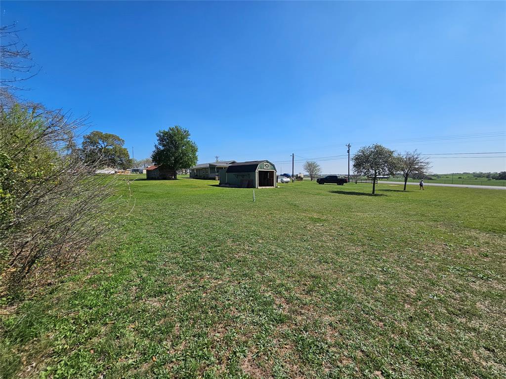 From the back left corner of the property. Shed two features a roll up garage door and a side door.