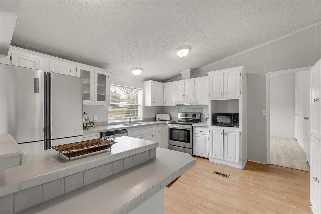 Island in kitchen and a wall of cabinets