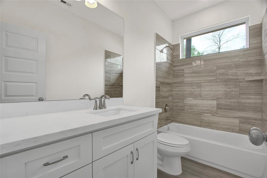 Second bathroom with Quartz Counter top and  Tub Shower combo with nice tile