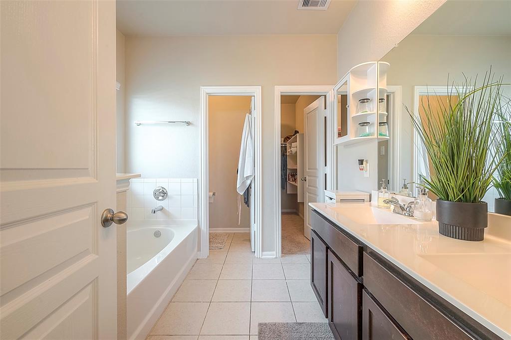 Stunning primary bathroom offers a  bathtub, separate shower and double sinks.