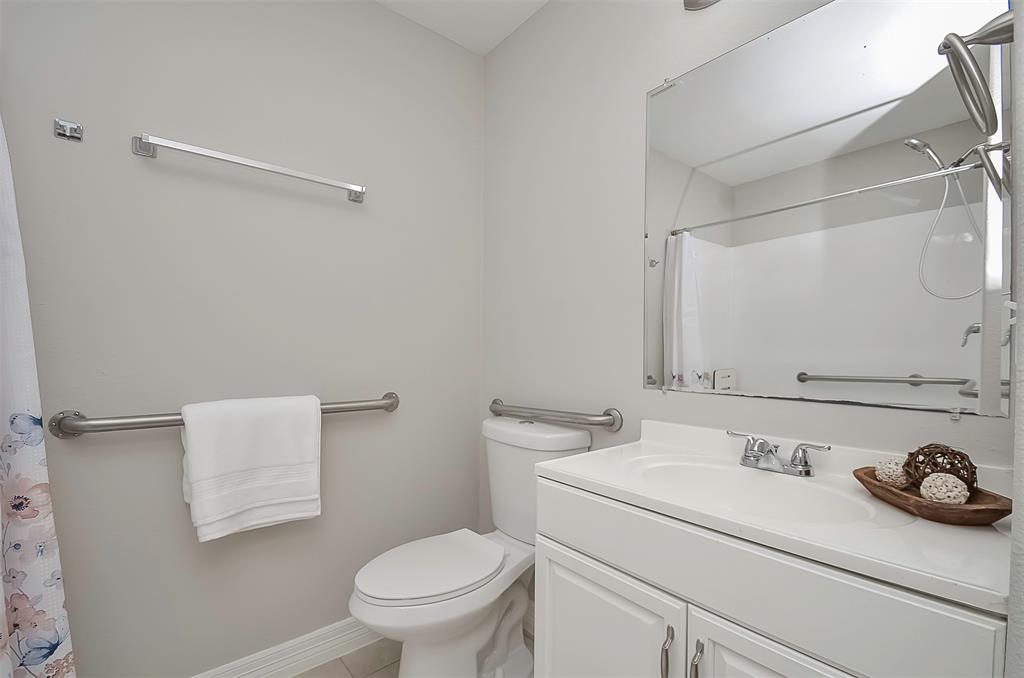 A clean, modern bathroom with a toilet, sink, and shower.