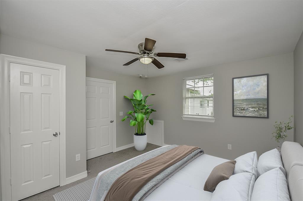 Upstairs room with carpet, ceiling fan, and window with blinds.