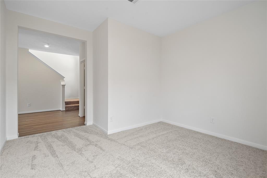 Quietly nestled in front of the home is the handsome home office. Featuring plush carpet, custom paint, recessed lighting and a large window.