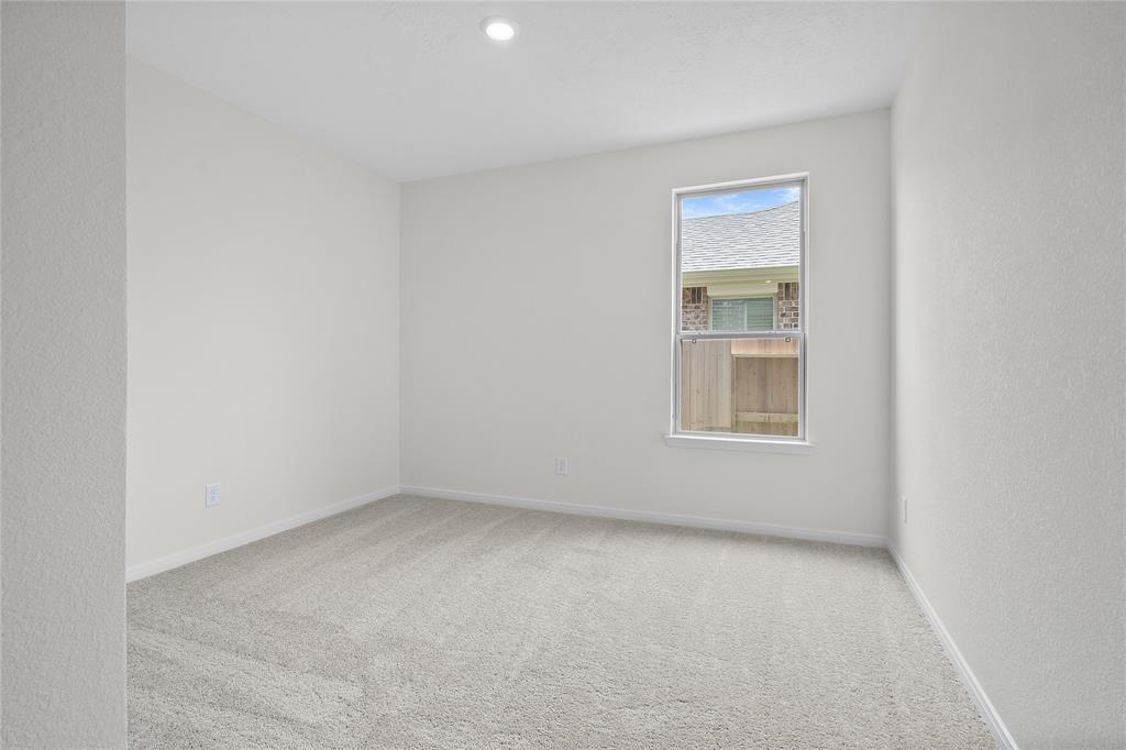 Secondary bedroom features plush carpet, custom paint and a large window.