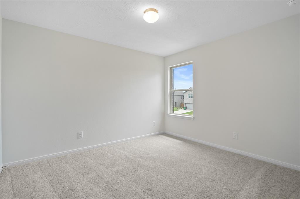 Secondary bedroom features plush carpet, custom paint and a large window.