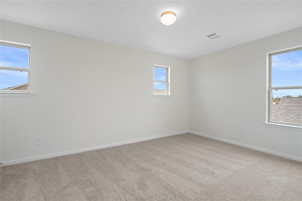 Secondary bedroom features plush carpet, custom paint and a large window.