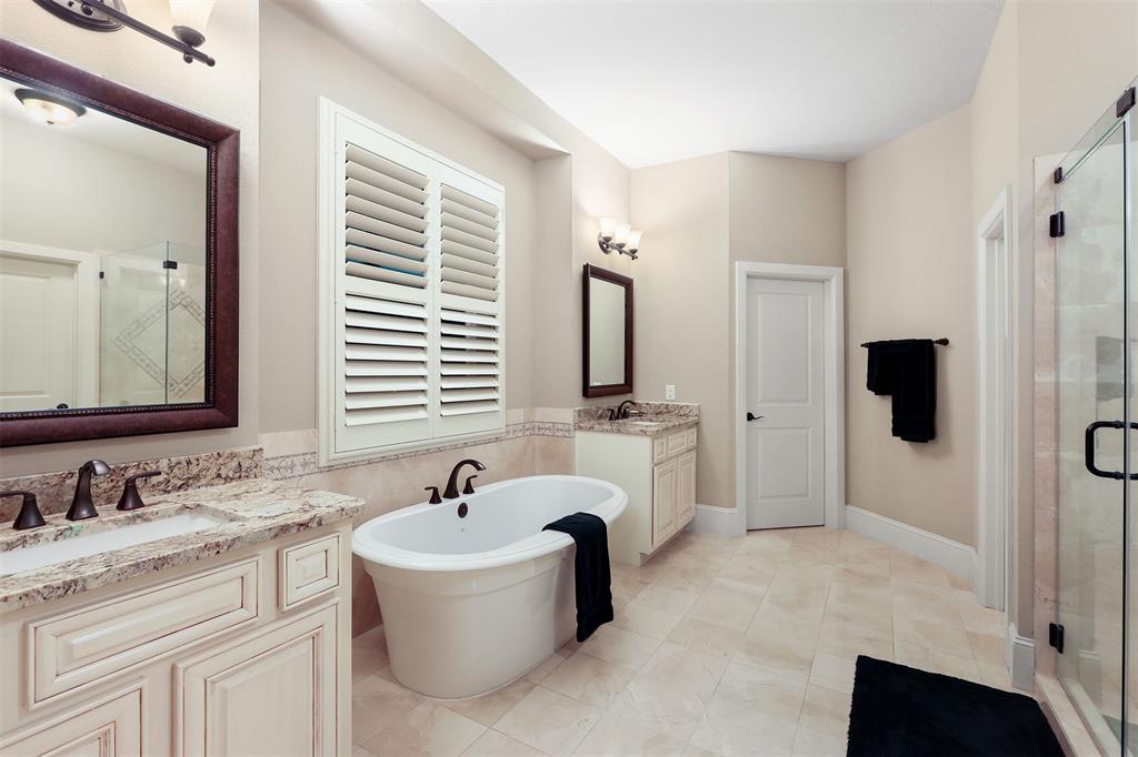 Granite counters, framed mirrors and a soaker tub in the master bathroom.