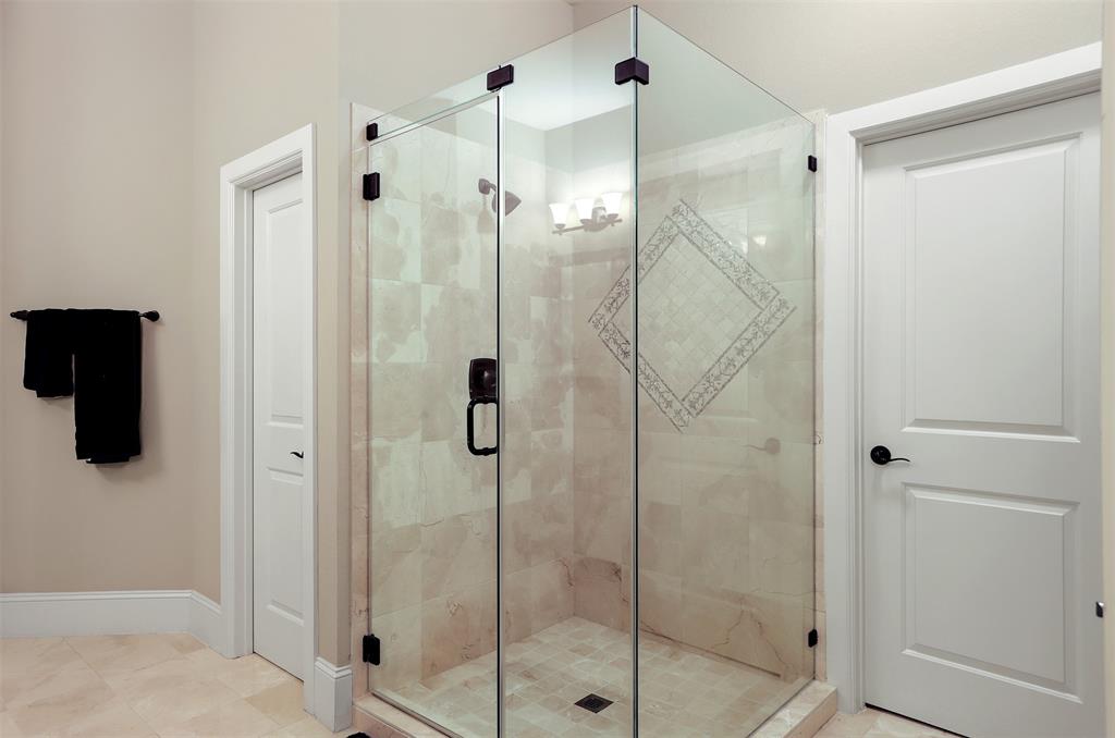 Frameless shower with travertine. There are two closets