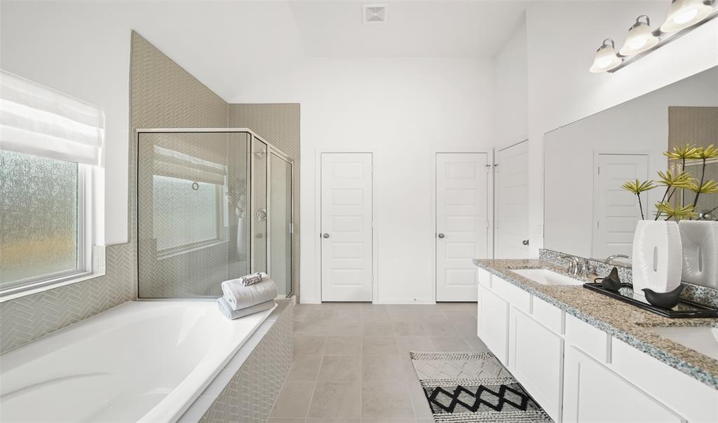 Luxurious bath with double vanities, separate soaker tub, walk-in shower and walk-in closet