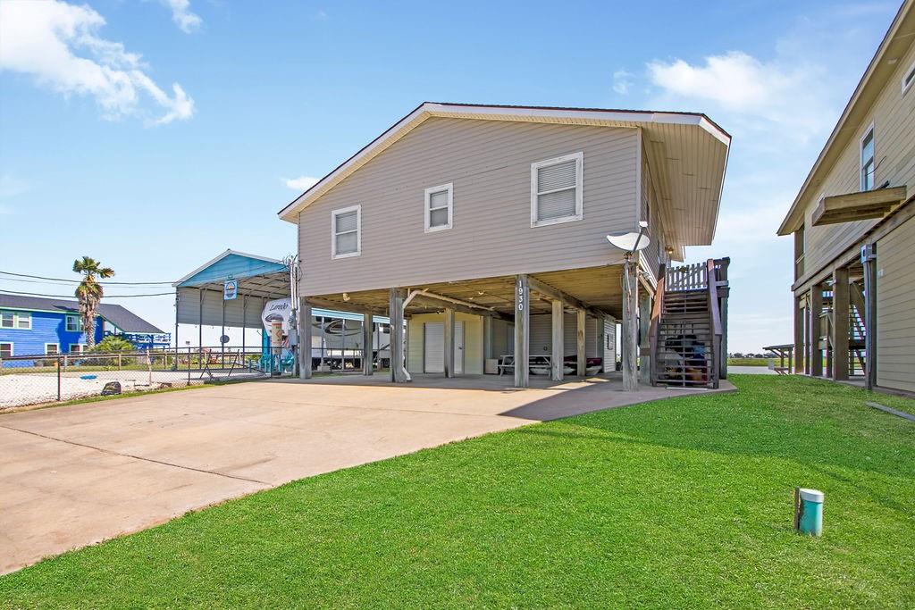 Roadside view of the house, with 2 storage areas and 3 areas to park.  Concrete driveway and 2 stairways to go upstairs.