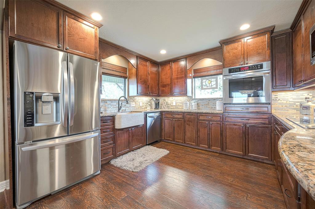 Large cabinets and granite counter space provide plenty of room to prepare meals, while stainless steel appliances and an oversized stainless refrigerator make it easy to store and prepare food. The detailed backsplash adds a touch of luxury and sophistication.