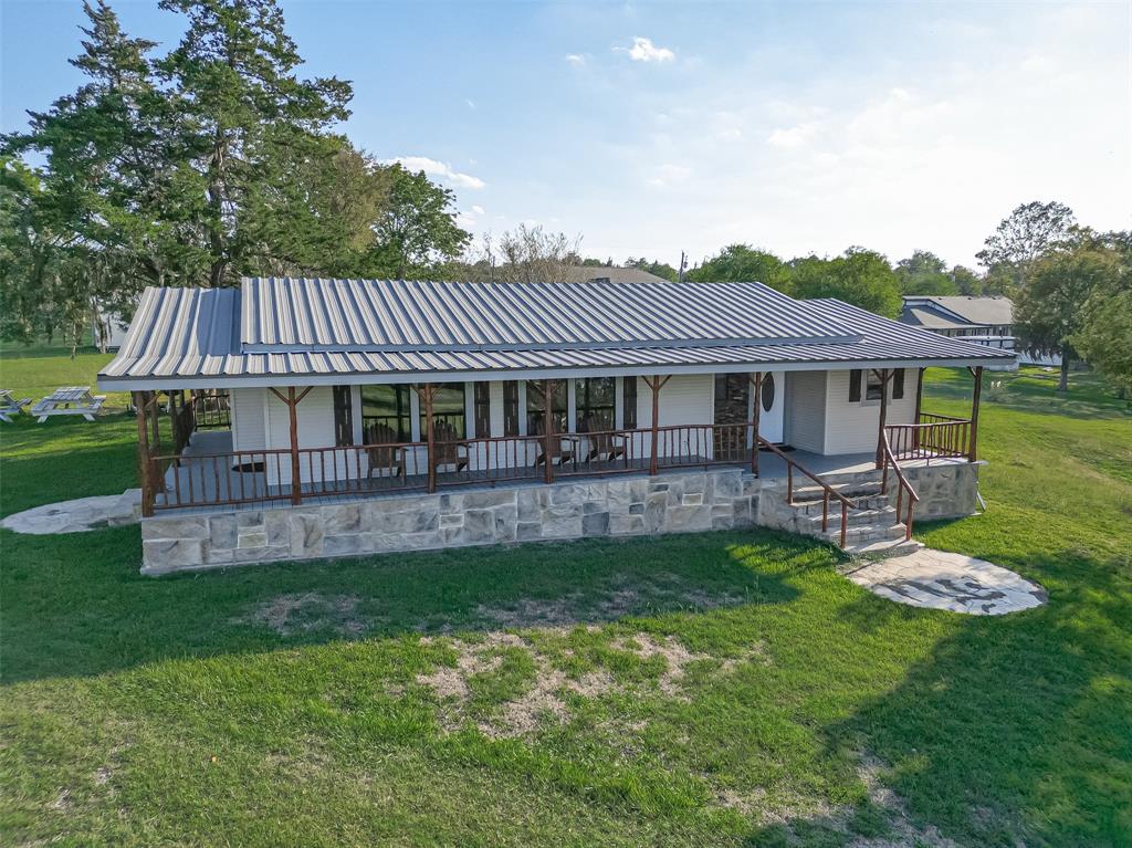 Step out onto the wrap-around covered porch of this charming home and enjoy the view of your spacious backyard. The porch is the perfect place to relax and unwind on a warm summer day, or to entertain friends and family. Stone steps lead down to the green grass and open yard, which is perfect for children to play in or for pets to run around.