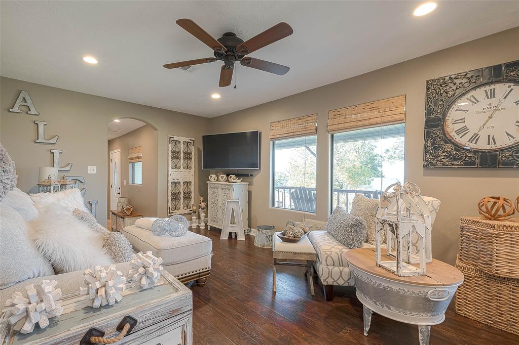 Step inside to your cozy living room with its large windows that let in plenty of natural light. The neutral colors and wood floors create a warm and inviting atmosphere, and the archway leading to the bedrooms adds a touch of charm.