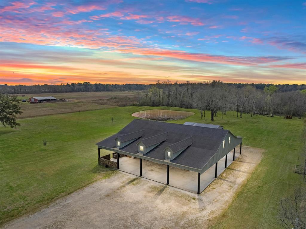 10-Acre Tract with a Custom, Barndo Inspired Home. This Distinguished property sits just 30 minutes East of downtown Houston in the bustling town of Crosby. Resting behind a gated entrance, the property offers rectangular footprint w/ 490' of road frontage and 990' in length. The front majority is cleared, level pasture, and the rear portion hosts a pond and partially wooded thicket. Functional, Southern Elegance comes to mind when describing the residence. 4 Bedrooms | 2.5 Bath, over 4,500SqFt of living space & nearly 3,700SqFt of covered Porch/Carport! The insulated, rollup garage doors add a unique touch to indoor/outdoor living, seamlessly tying the covered outdoor area w/ interior living. The first level consists of an expansive family room, an even larger game room, and kitchen w/ extended dining/sitting. Primary suite w/ private covered porch. 3 Bedrooms & game room upstairs. Separate Shop w/ finished office space + storage. The list goes on! Such a rare property!