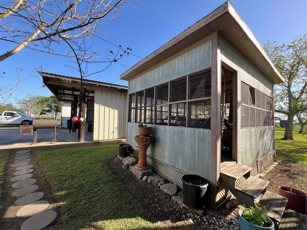 Beautiful green grass in the yard, partially fenced yard, shade trees, left side of home, back of garage/workshop.