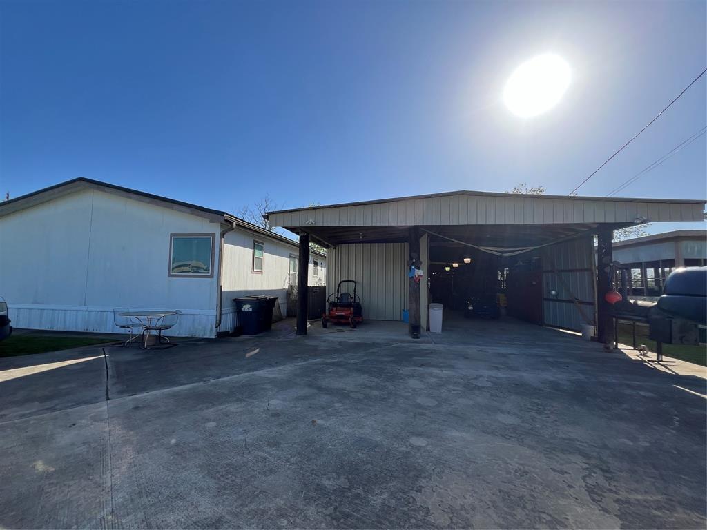 The side of the home is on the left, the carport, garage/workshop in the middle, hot tub room on the right.