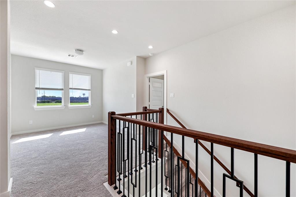 Another view of upstairs with primary and secondary bedrooms on opposite areas of the living space.