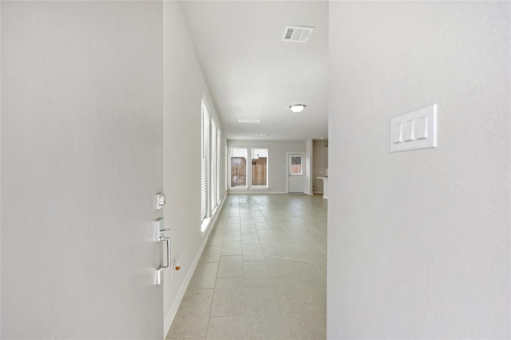 Entry into the North Hampton floor plan shows deep space with tile flooring and plenty of natural light through MANY blind covered windows.