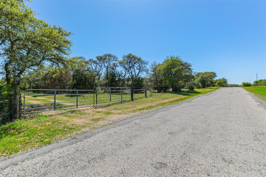 Spectacular property nestled deep in the rare Piney-Woods of Hallettsville! Enjoy the scenic drive on a fully paved route to the double gate entrance. You will drive inward a bit before you notice the beginning of the (Pine) TREE-LINED DRIVEWAY (an Easement). The impressive view of the Towering Pines along with the illustrious smell of the trees and fresh country air will ignite the senses as you drive the windy way to the Official Property Entrance. Upon entering you will notice a SOLAR Powered WATER WELL and Large Water Tank used to supply drinking water to the area's wildlife via a Concrete Stock Tank. To the left you will notice 2 cleared paths, great for walking, riding UTV's or Horses. Both Paths lead back to the front gate and creat a loop near the perimiter of the property, while staying on the inside of the rivine. Great SECLUSION, for Hunting, Relaxing, Camping, Homesteading, Riding Horses,  Exploring & More!