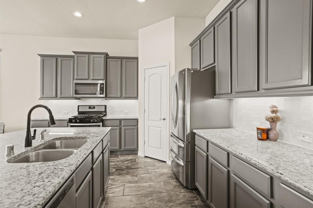 Every meal becomes a masterpiece in this thoughtfully designed kitchen, equipped with modern stainless steel appliances including a gas oven/range, and built-in microwave.