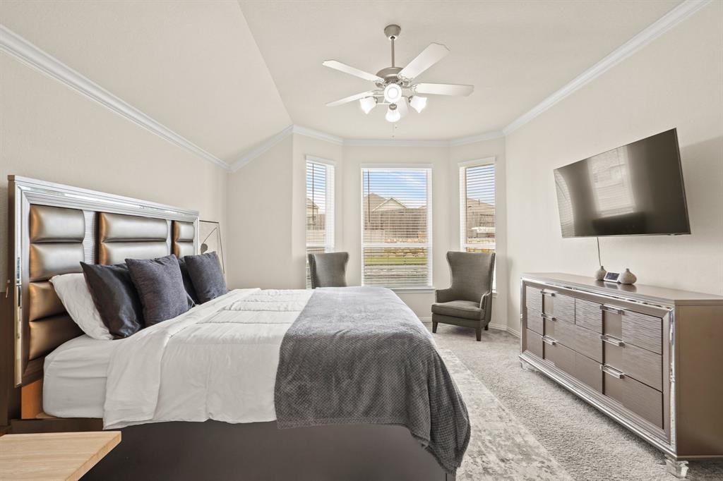 Discover timeless sophistication in this Primary Suite, which also features intricate crown molding and a refreshing ceiling fan to create the ultimate environment for relaxation and rejuvenation.