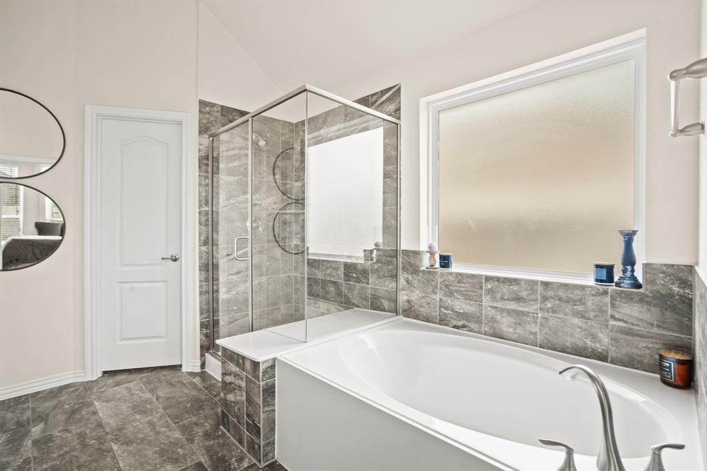 Enjoy the option of a relaxing garden tub and separate glass-enclosed shower, both with lovely tile surround which carries effortlessly across the floor.