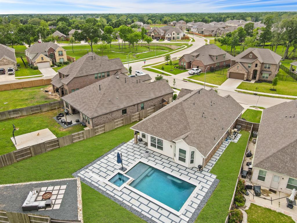 An aerial view reveals the epitome of relaxation and luxury, where a 30x17\' pool and inviting spa await, surrounded by unique decking for endless ways to enjoy the great outdoors.