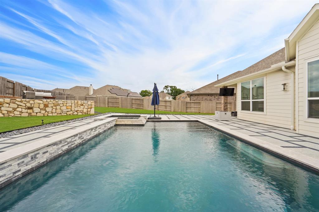 Every detail of this pool was meticulously designed to exude luxury and convenience; travertine coping, pebble plaster, a pool bench, tanning area, salt system, auto fill water level, raised wall with water features, and more.