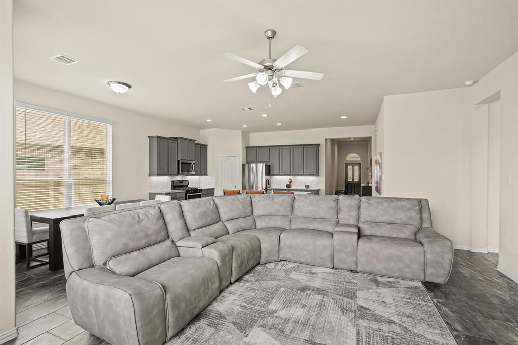 The family room flows gracefully to the breakfast space and kitchen in this fantastic open-concept floor plan. Gleaming tile floors and inviting raised ceilings carry throughout.