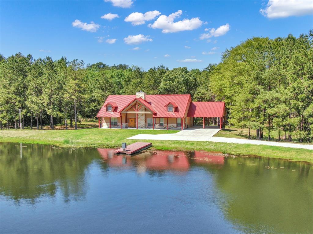 This stunning property boasts a spacious 3 bed, 3 full bath home with a waterfront view and an upstairs loft, all situated on 32.8 acres of land. Enjoy the convenience of a 2 car carport, a 2 acre pond, a camphouse with a big smoker, and a 30x42 shop with the option to add electricity. Additional features include 3 empty lots for potential housing, each with their own electric poles, water meters, and septic tanks. Separate from the main house, you'll find a 2 car garage, a 3 car carport, a barn, and a storage building. Outdoor enthusiasts will appreciate the 2 deer stands, 2 deer feeders, that are optional to purchase. For added convenience, there is the option to purchase a tractor, zero turn mower, and furniture. Don't miss out on this incredible opportunity to own your own piece of paradise!
