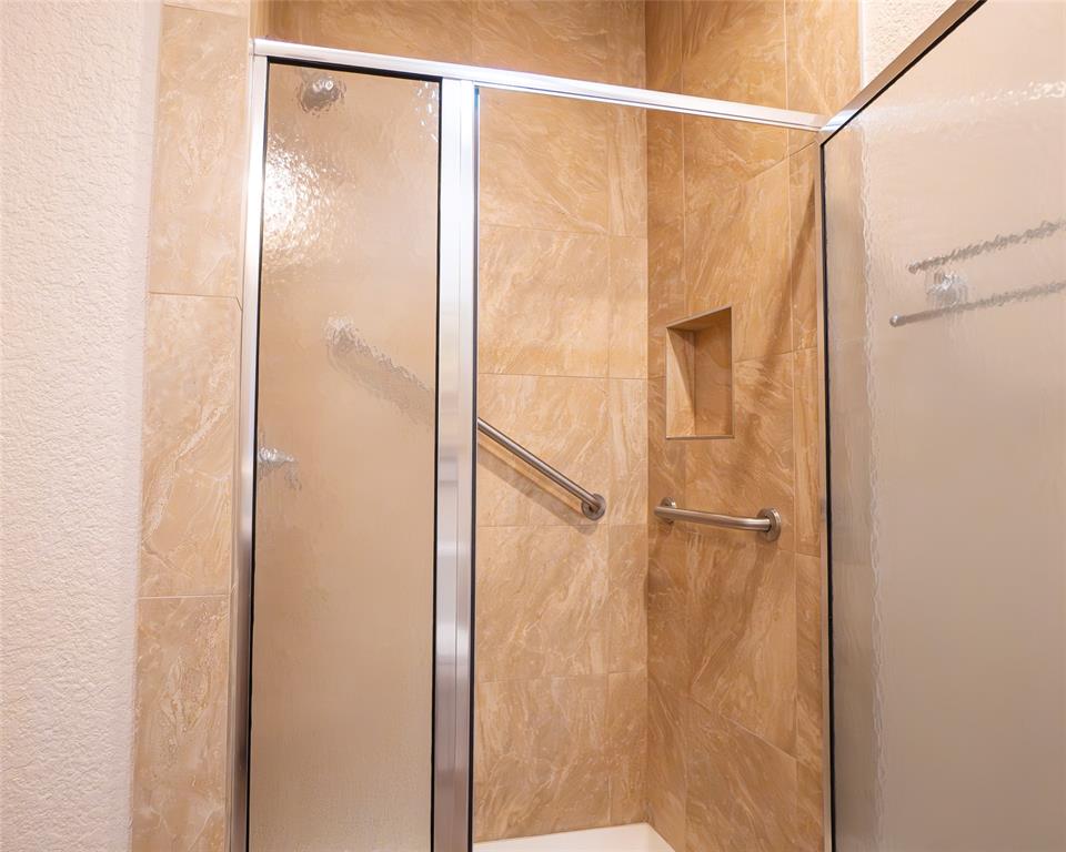 Downstairs en-suite bathroom:Main floor Mini-Master\'s private full bathroom has roomy shower with handrails.