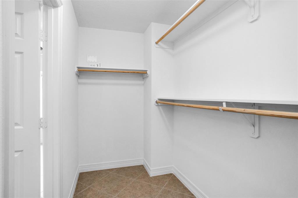 Primary Bedroom closet w/ tile floors offers lots of hang space.