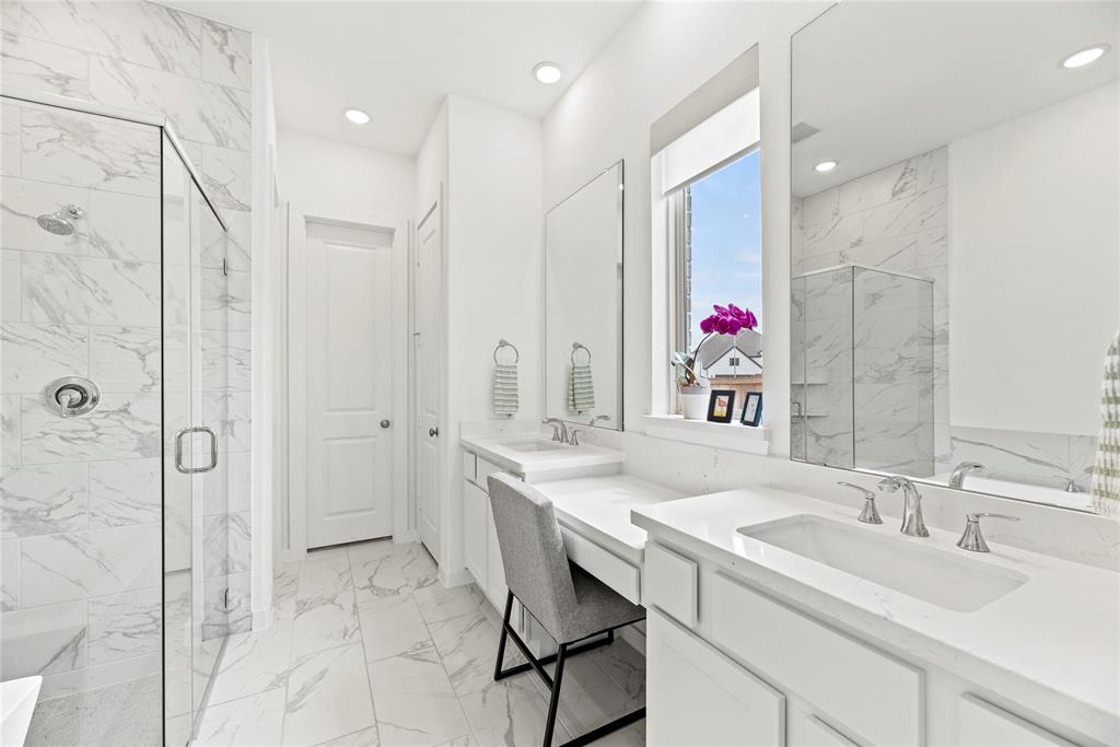 The primary bath offers dual vanities with plenty of storage. There is so much space to get ready here.