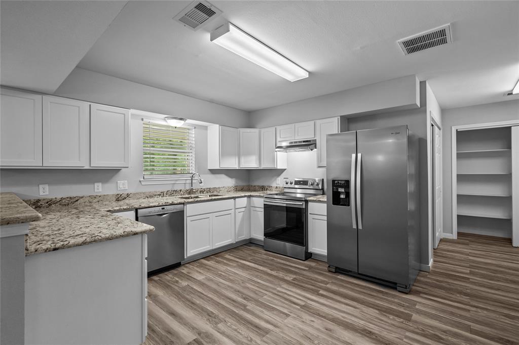 A view looking toward the kitchen and large pantry off to the side.