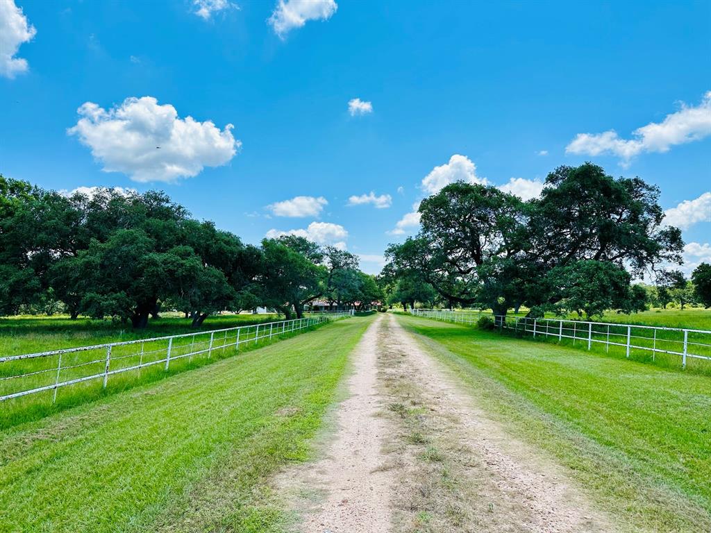 Beautiful 56 acre ranch (per survey) 75 miles from Downtown Houston, 45 miles from Matagorda Bay, ideal for anyone looking for a convenient getaway from city life.  Live now, build later! Well maintained property with mature oak trees and rolling pastures that is fully fenced with cross fencing.  The acreage can accommodate livestock or can be used for deer or duck hunting with Mustang Creek running through the east portion of the land. The 4 bedroom, 2.5 bath home with 2 car garage, additional RV parking, and covered pool in the fenced backyard. Inside you will find a large den, formal living, 2 fireplaces, formal dining, kitchen open to a cheery sunroom, primary suite overlooking the pool, plus 3 large guest bedrooms, and full hall bathroom. Sprinklers are installed around the home and there is additional electricity available for future barn.  Well water.  Estate sale, conveys in "as is" condition. Home and pool have never flooded and are protected by a levy. Louise ISD schools.