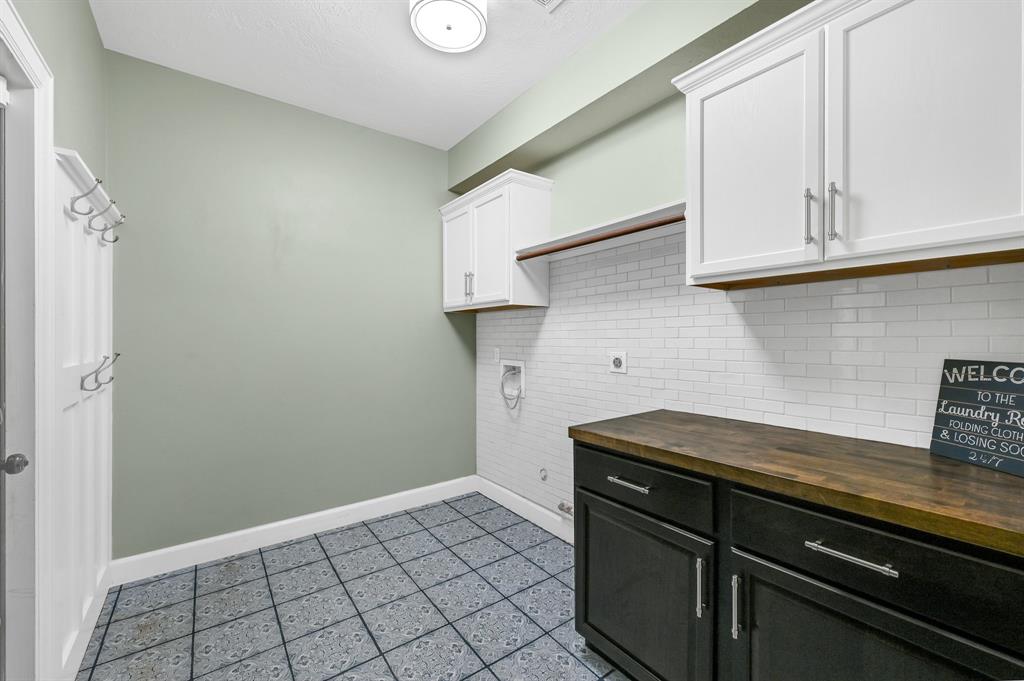 Updated laundry room with plenty of room for storage.