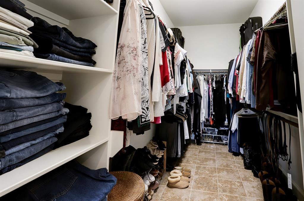 Spacious walk-in closet with ample shelving and hanging space to accommodate a large wardrobe.