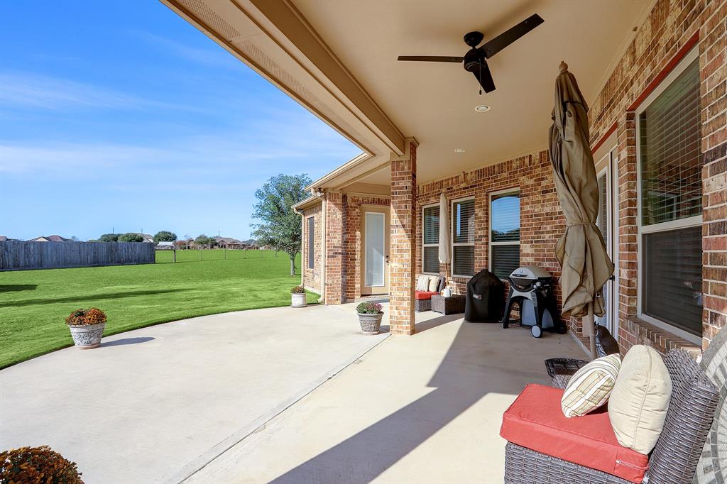 Enchanting outdoor patio offering views of a garden, charming garden house, and large backyard.